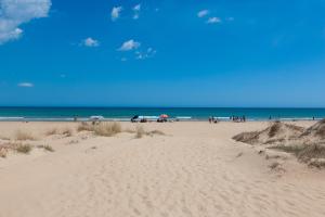 a beach with a group of people walking on the sand at Casa Viga in Tre Fontane