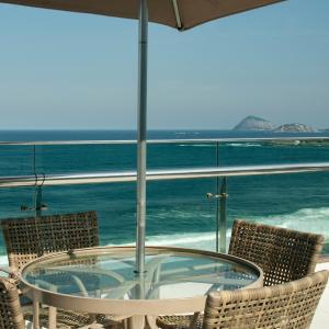 
a patio area with chairs, tables and umbrellas at Arena Copacabana Hotel in Rio de Janeiro
