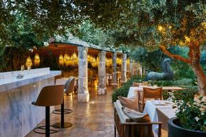 シウタデリャにあるFaustino Gran Relais & Chateauxの庭園内のテーブルと椅子付きのレストラン