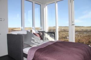 una camera con letto e ampie finestre di Strýta Apartment 2 a Ölfus