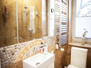 ein Bad mit einem Waschbecken, einer Dusche und einem WC in der Unterkunft Apartament Sunset Boulevard z tarasem dla 4 gości in Gdynia