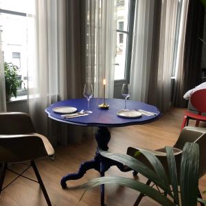 a blue table with two glasses and a candle on it at Daen’s Greenhouse in Utrecht