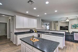 a kitchen with white cabinets and a black counter top at Game Room and Pool Spacious Queen Creek Home! in Queen Creek