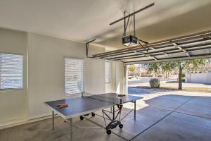 a ping pong table in a room with a ping pong racket at Game Room and Pool Spacious Queen Creek Home! in Queen Creek