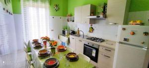 eine Küche mit einem Tisch und Geschirr darauf in der Unterkunft La casa del sole "tra l'Etna e il mare" in Acireale