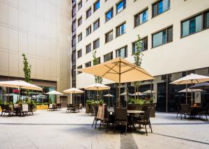 an outdoor patio with tables and chairs and umbrellas at Maldron Hotel Newcastle in Newcastle upon Tyne