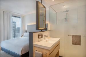 a bedroom with a bed and a sink and a mirror at INNSiDE by Meliá Amsterdam in Amsterdam