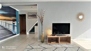 uma sala de estar com uma televisão e um vaso em Villa les Palmiers - Aux Portes d'Alès em Saint Julien Les Rosiers