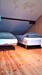 Duas camas num quarto com piso em madeira em Villa les Palmiers - Aux Portes d'Alès em Saint Julien Les Rosiers