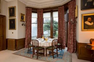 a dining room with a table and chairs and a window at Crookston House B&B 