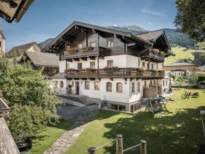 ein großes Haus mit Balkon und Hof in der Unterkunft Kinderbauernhof Scharrerhof in Hollersbach im Pinzgau