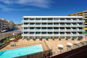 un grande edificio bianco con piscina di Apartamentos Strelitzias a Playa del Ingles