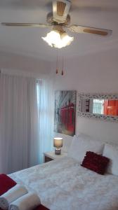 um quarto com uma cama e uma ventoinha de tecto em La Grâce, Durbanville em Cidade do Cabo