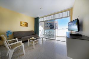 A television and/or entertainment centre at Apartamentos Strelitzias