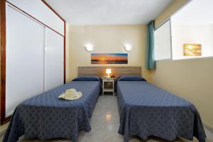 A bed or beds in a room at Apartamentos Strelitzias