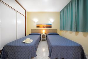 A bed or beds in a room at Apartamentos Strelitzias Még 37 kép