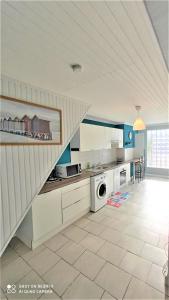 a kitchen with white cabinets and a staircase at Villa les Palmiers - Aux Portes d'Alès in Saint Julien Les Rosiers