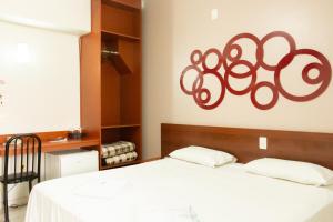 een slaapkamer met een bed met een bord aan de muur bij Contagem Centro Hotel in Contagem