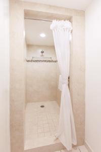 a shower with a white curtain in a bathroom at El Cid Marina Beach Hotel in Mazatlán