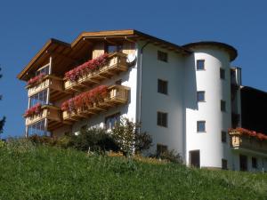 ein weißes Gebäude mit Balkon auf einem Hügel in der Unterkunft Haus Lentsch in Kaunerberg