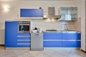 a kitchen with blue cabinets and a sink at CASA ALESSANDRO CON PISCINA LAGO DI GARDA in Salionze