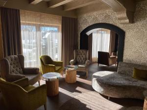 sala de estar con sillas, mesa y ventanas en Hotel Fohlenhof, en Ampfing