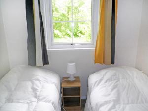 2 camas en un dormitorio con ventana en Holiday Home Den Oever by Interhome, en Den Oever