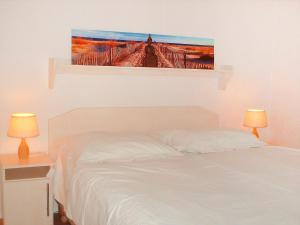 Un dormitorio con una cama con un cuadro en la pared. en Holiday Home Den Oever by Interhome, en Den Oever