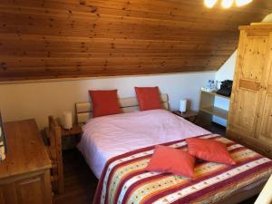 een slaapkamer met een bed met rode kussens bij B&B Carisma in Lochristi