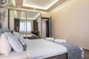 a bedroom with a white bed and a large mirror at Apartments Cats in Varna City
