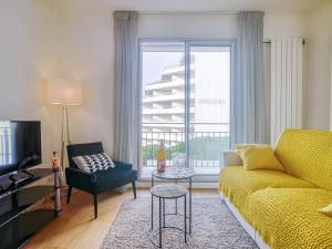 ein Wohnzimmer mit einem gelben Sofa und einem Fenster in der Unterkunft Apartment Océana by Interhome in Biarritz