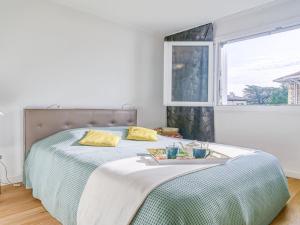 ein Schlafzimmer mit einem großen Bett mit Fenster in der Unterkunft Apartment Océana by Interhome in Biarritz