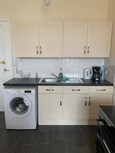 cocina con fregadero y lavadora en WIGHTHOLIDAY en Ryde