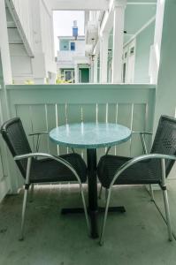 a glass table and chairs on a balcony at Pacific Blue Inn in Santa Cruz