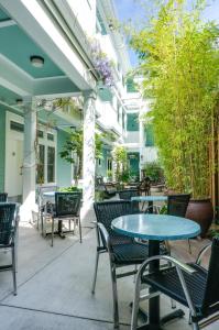 un patio al aire libre con mesas, sillas y árboles en Pacific Blue Inn en Santa Cruz