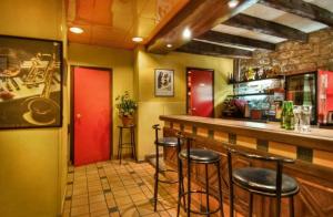 - un bar avec tabourets dans un restaurant aux portes rouges dans l'établissement Hotel Le Faubourg Opera, à Paris