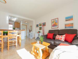 a living room with a couch and a table at Apartment Roquemar by Interhome in L'Ampolla +9 photos