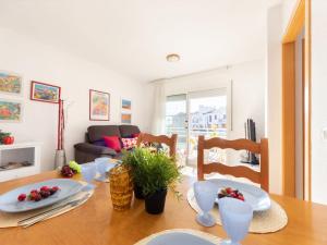 a dining room with a table with plates and fruit on it at Apartment Roquemar by Interhome in L'Ampolla