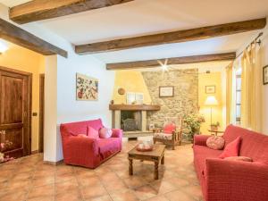 - un salon avec deux chaises rouges et une cheminée en pierre dans l'établissement Holiday Home La Fenice by Interhome, à Camporgiano