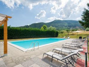 uma piscina com um monte de cadeiras à volta em Holiday Home La Fenice by Interhome em Camporgiano