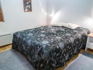 a bedroom with a bed with a black and white blanket at Holiday Home Alppitalo sinitähti 9 apt 2 by Interhome in Tahkovuori