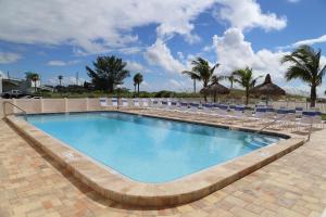 una piscina con sillas azules y un complejo en 101 Beach Place Condos, en St Pete Beach