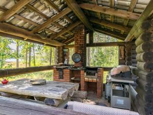 una cocina al aire libre con mesa y fogones en una cabaña en Holiday Home Telkänkolo by Interhome, en Pertunmaa
