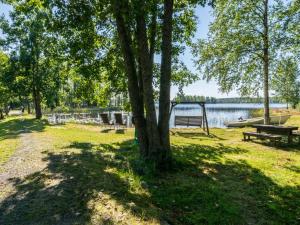 un parque con bancos y un árbol junto a un lago en Holiday Home Telkänkolo by Interhome, en Pertunmaa