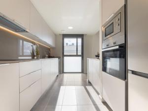 een keuken met witte kasten en roestvrijstalen apparaten bij Apartment Alzina B by Interhome in Cambrils