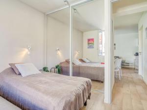 1 dormitorio con 2 camas y espejo en Apartment Chalet Louisette by Interhome, en Biarritz