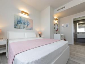 een witte slaapkamer met een groot bed en een spiegel bij Apartment Alzina B by Interhome in Cambrils