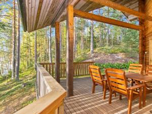 a porch with a wooden table and chairs on it at Holiday Home Römpsi by Interhome in Iitti