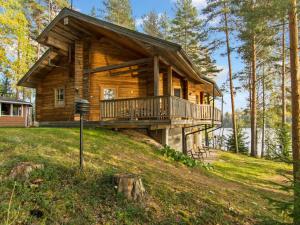a log cabin in the woods with a wrap around deck at Holiday Home Römpsi by Interhome in Iitti