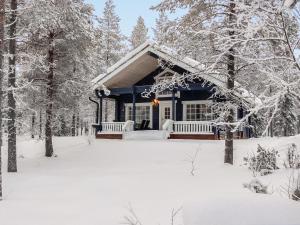 a house covered in snow in the woods at Holiday Home Keselmäkangas by Interhome in Tikkala